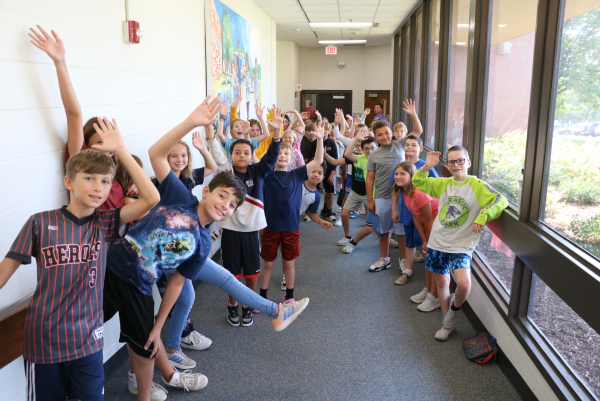 Kids in the hallway at Neihardt waving.
